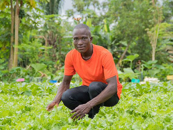 Een jonge boer uit Benin bewerkt zijn veld.